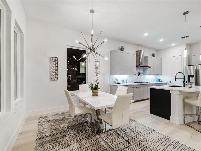 Dining room featuring light wood finished floors, a chandelier, and recessed lighting Dining room featuring light wood finished floors, a chandelier, and recessed lighting