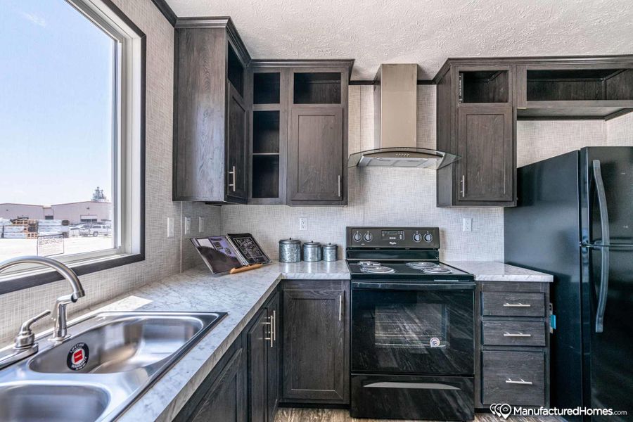 Well-lit kitchen with a modern aesthetic, featuring ample counter space and dark wood cabinetry.