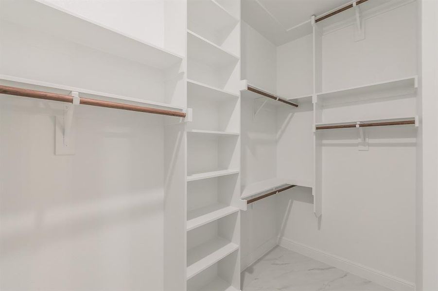 Spacious closet with light marble finish flooring Spacious closet with light marble finish flooring