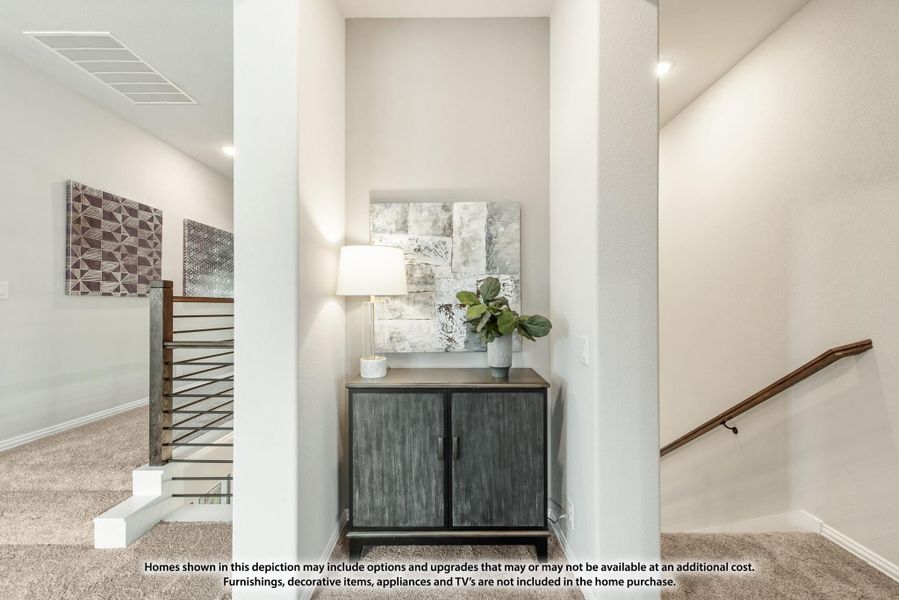 Upstairs hallway with decorative cabinet, wall art, and staircase with modern metal railing and wood handrail