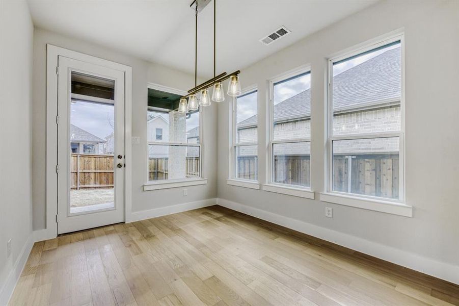 Unfurnished dining area featuring light wood-style flooring and healthy amount of natural light