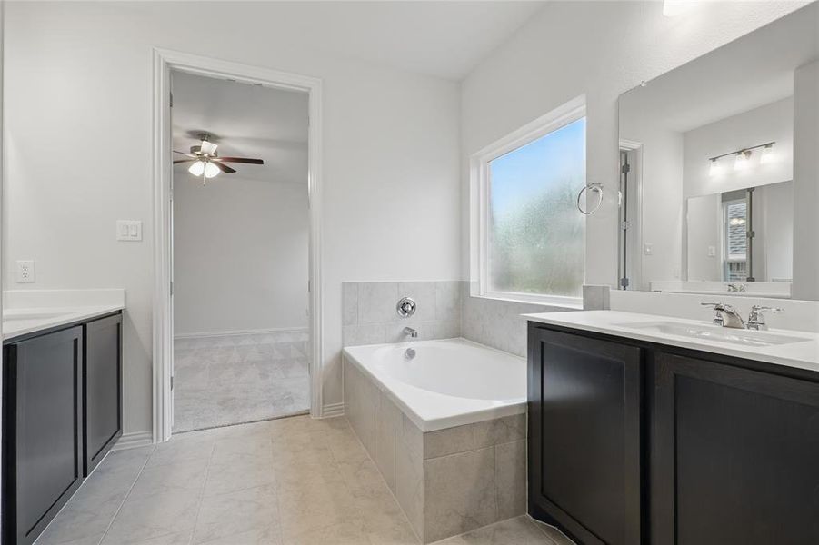 Bathroom with ceiling fan, two vanities, and a bath Bathroom with ceiling fan, two vanities, and a bath