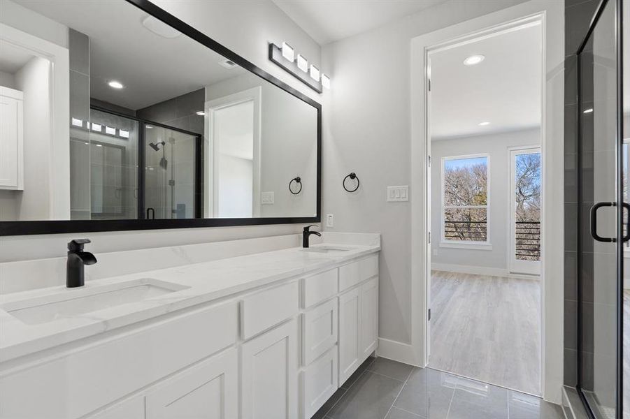 Bathroom with walk in shower, tile patterned floors, and vanity