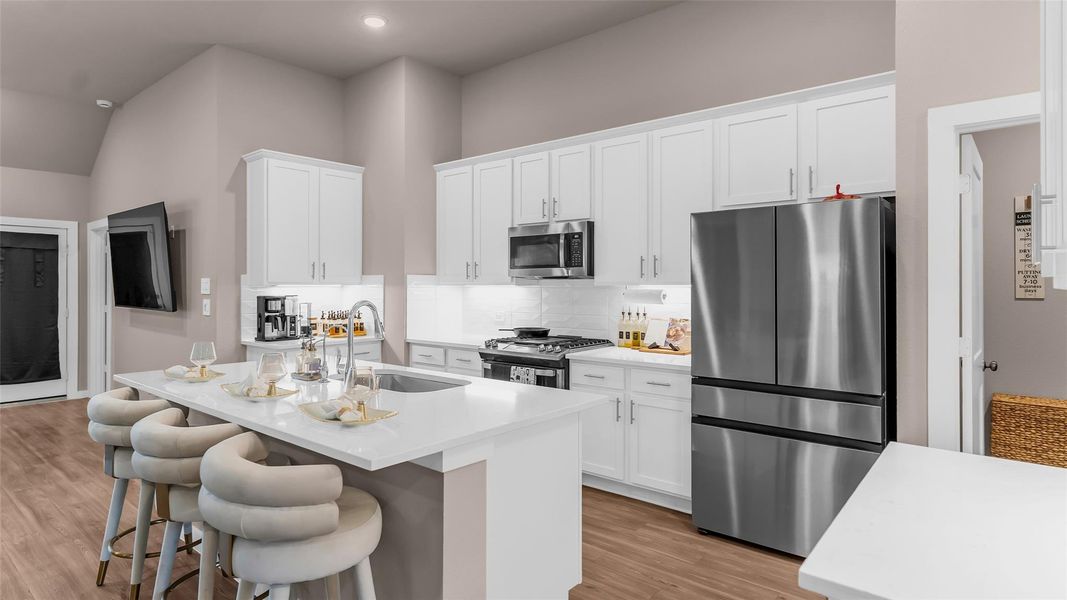 The Kitchen features a gas range, sleek modern cabinets, stylish back splash, large island with lots of storage.