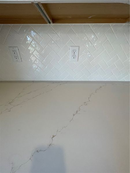 Refined tile backsplash and elegant countertops el