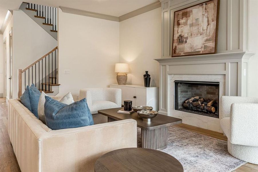 Living room with wood finished floors and a premium fireplace
