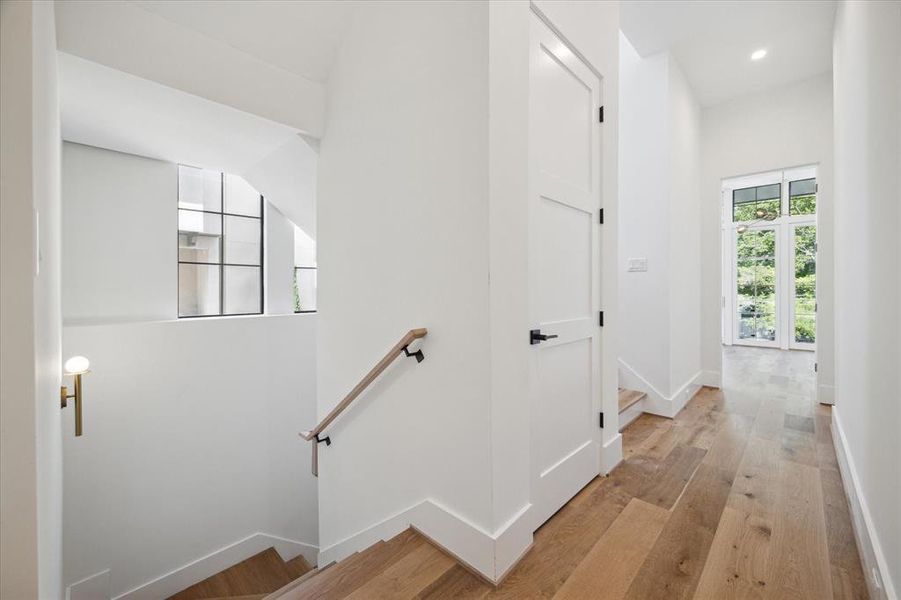 The windowed staircase wraps around convenient closet space in this elevator-read home.