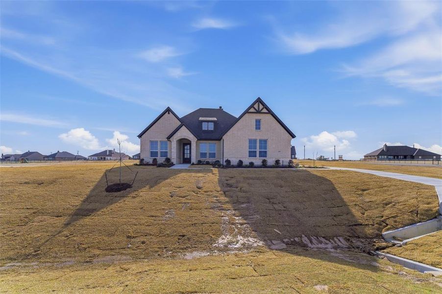 View of front of home with a front lawn and stone siding