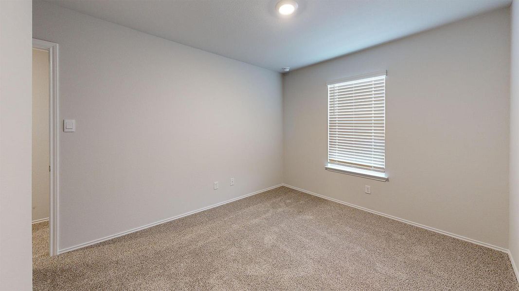 Carpeted spare room featuring baseboards
