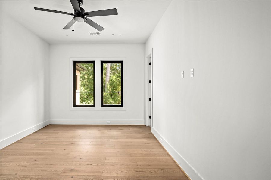 Secondary bedroom featuring clean lines, large windows, walk in closet, and ensuite bath. Perfect for guests or family.