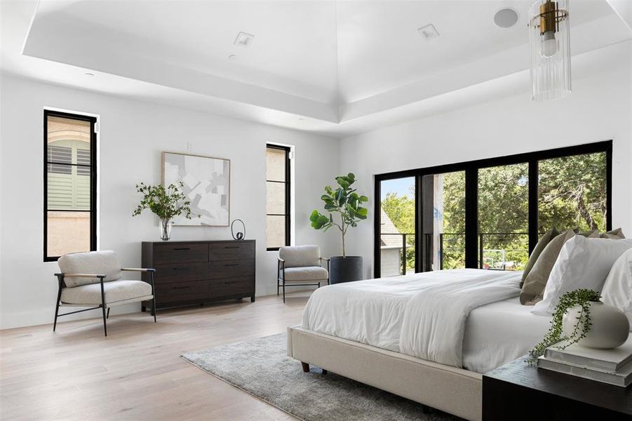 Bedroom with light hardwood / wood-style flooring and a high ceiling