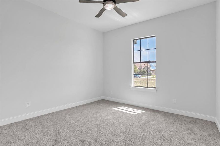 Carpeted spare room featuring ceiling fan