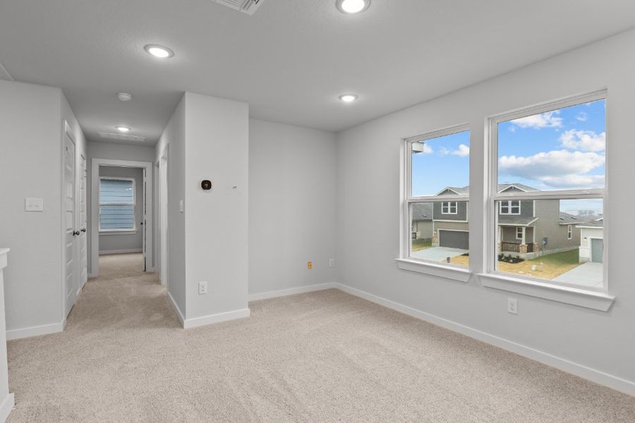 A room with a window and a door with a view of the ocean.