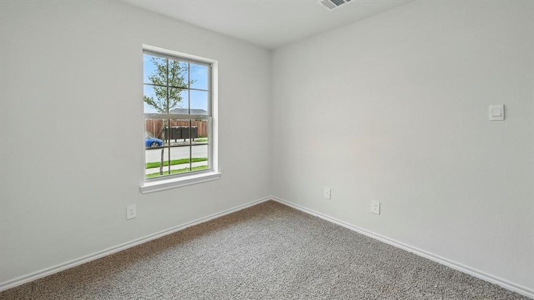 This room features light gray walls, gray carpeting, and a window with white trim
