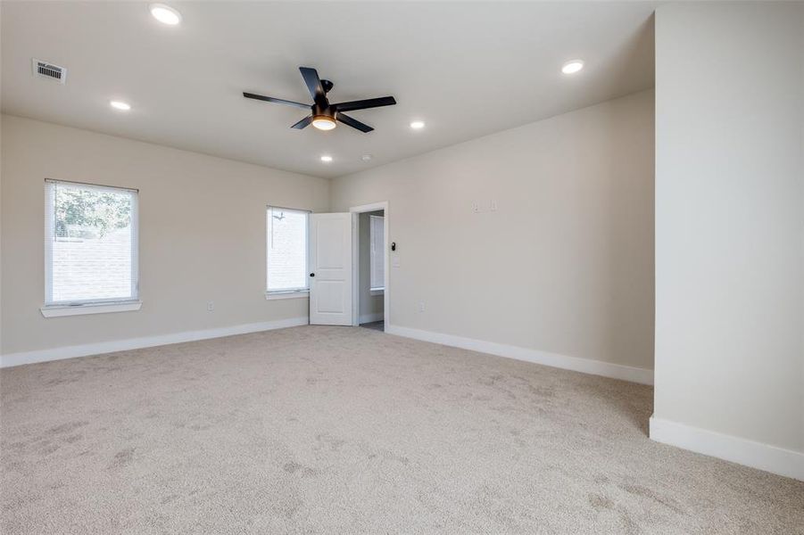 Unfurnished bedroom with light colored carpet, a ceiling fan, and recessed lighting