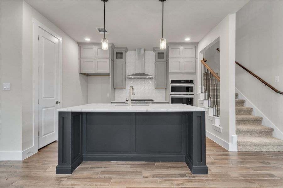 A well-appointed kitchen island anchors this inviting culinary space, steps from a carpeted staircase.