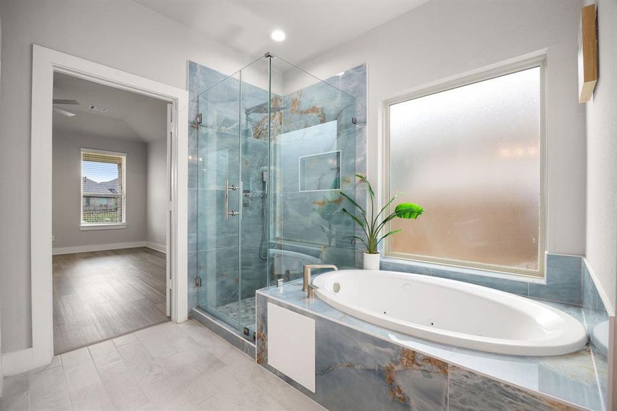 A combination of a bathtub with a large frosted window and a separate walk-in shower with beautiful tiles.