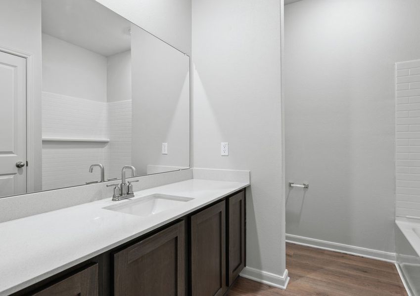 The secondary bathroom has a large vanity space and a shower-tub combo. The secondary bathroom has a large vanity space and a shower-tub combo.
