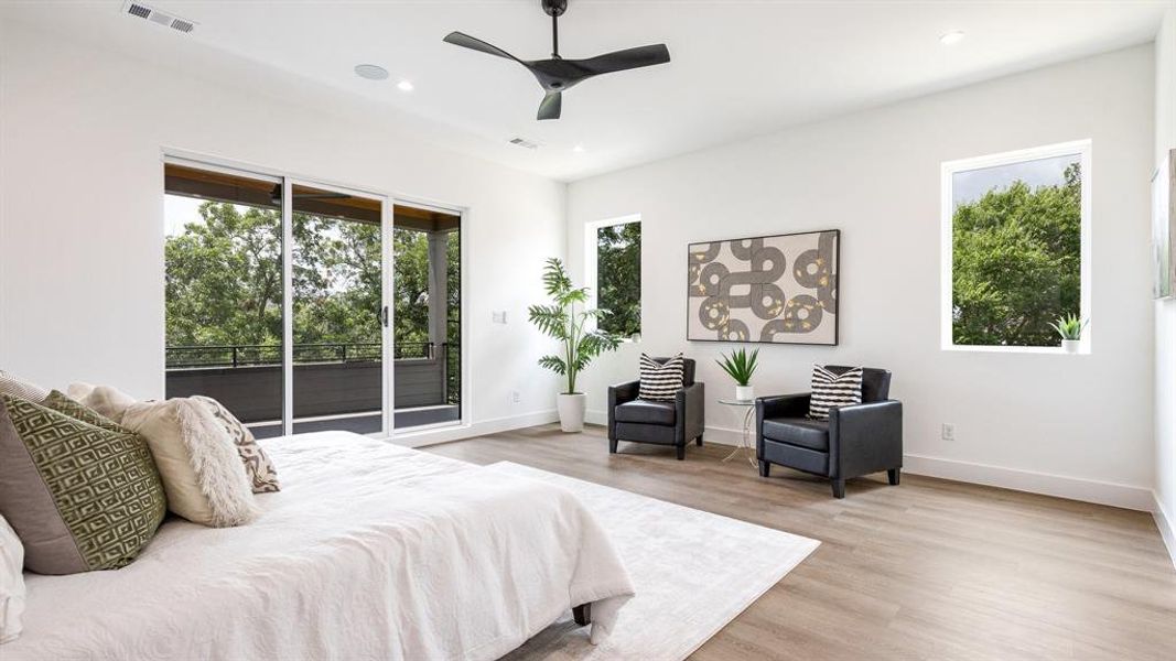 Bedroom with access to outside, light wood-type flooring, multiple windows, and ceiling fan