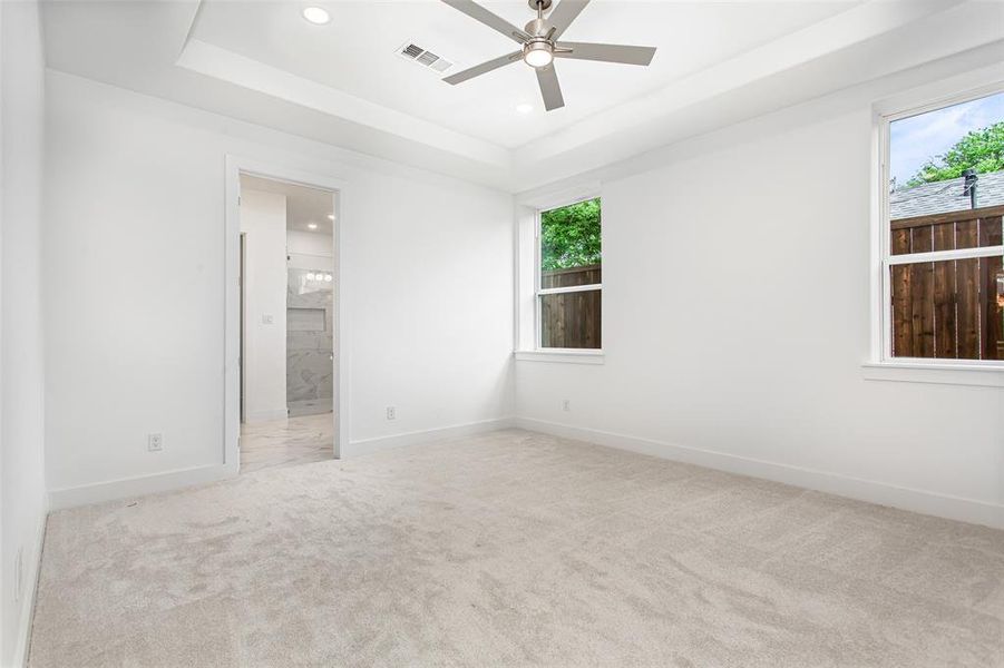 Unfurnished room featuring carpet flooring, ceiling fan, recessed lighting, a raised ceiling, and baseboards