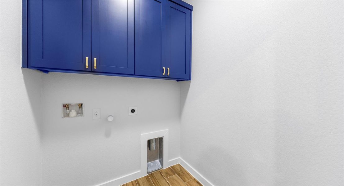 Laundry area with wood finish floors, cabinet space, hookup for a washing machine, electric dryer hookup, and gas dryer hookup