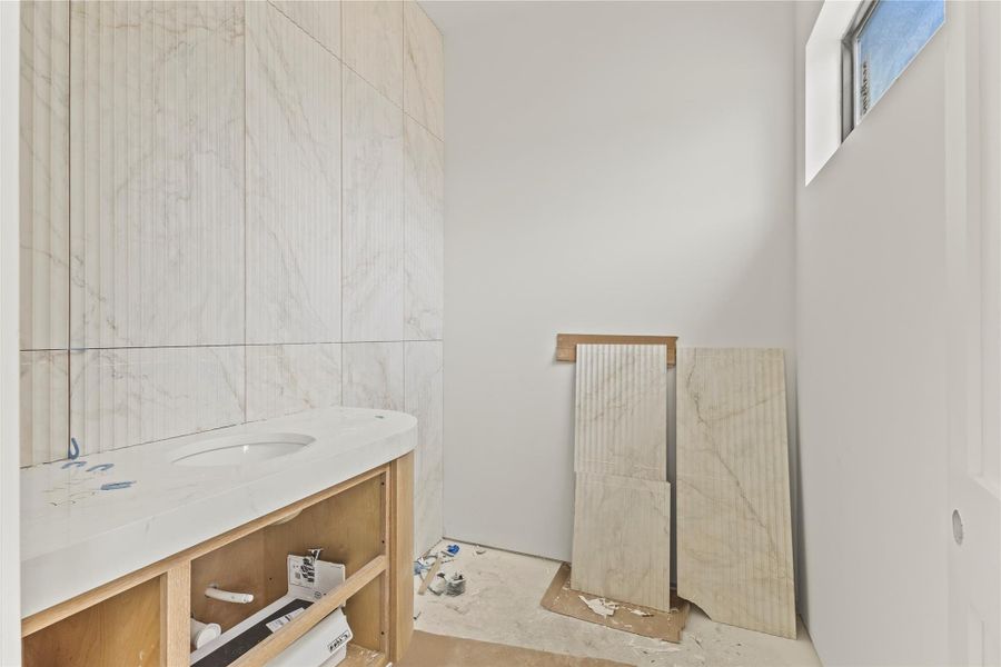 Curved vanity with an integrated sink, showcasing a light-colored countertop