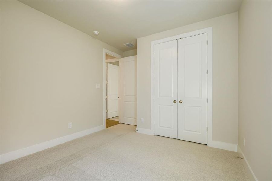 Unfurnished bedroom featuring carpet and a closet