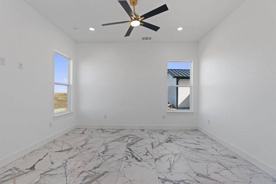 A well-lit bedroom features elegant tile flooring and a modern ceiling fan for ultimate comfort. A well-lit bedroom features elegant tile flooring and a modern ceiling fan for ultimate comfort.