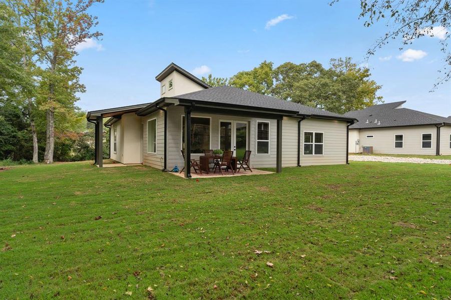 Rear view of property featuring a patio area and a lawn Rear view of property featuring a patio area and a lawn