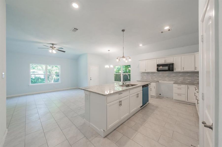 Kitchen with black microwave, dishwashing machine, plenty of natural light, tasteful backsplash, and recessed lighting Kitchen with black microwave, dishwashing machine, plenty of natural light, tasteful backsplash, and recessed lighting