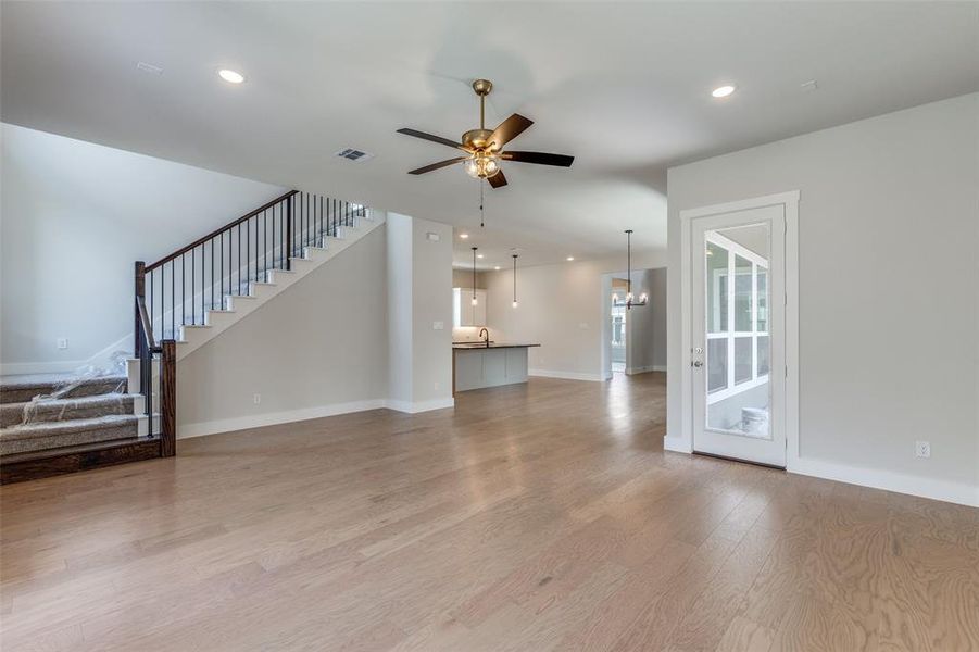 Unfurnished living room featuring sink, light wood-type flooring, and ceiling fan