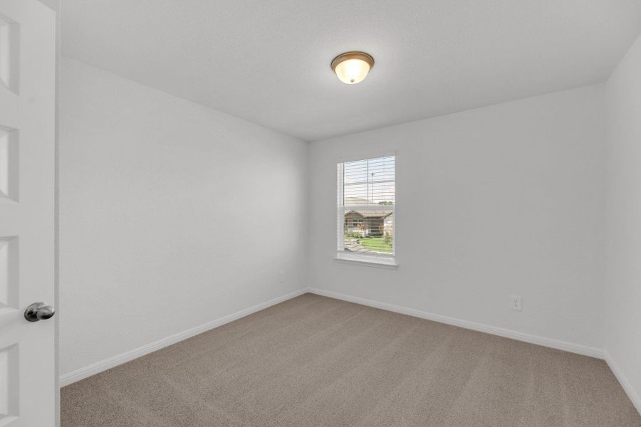 Spare room with light carpet and baseboards Spare room with light carpet and baseboards
