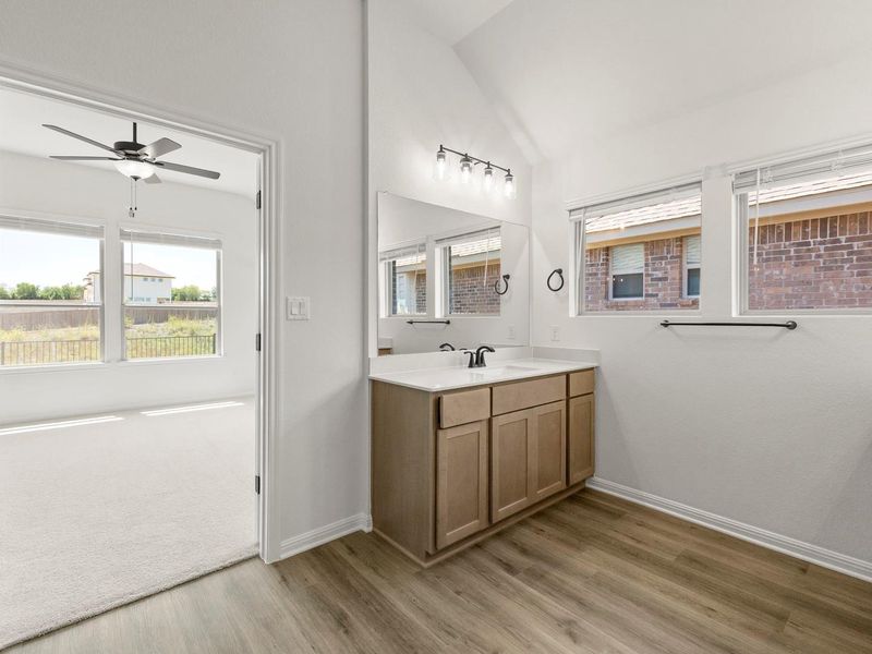 Bathroom vanity featuring wood-finish cabinetry, a white countertop, and an undermount sink