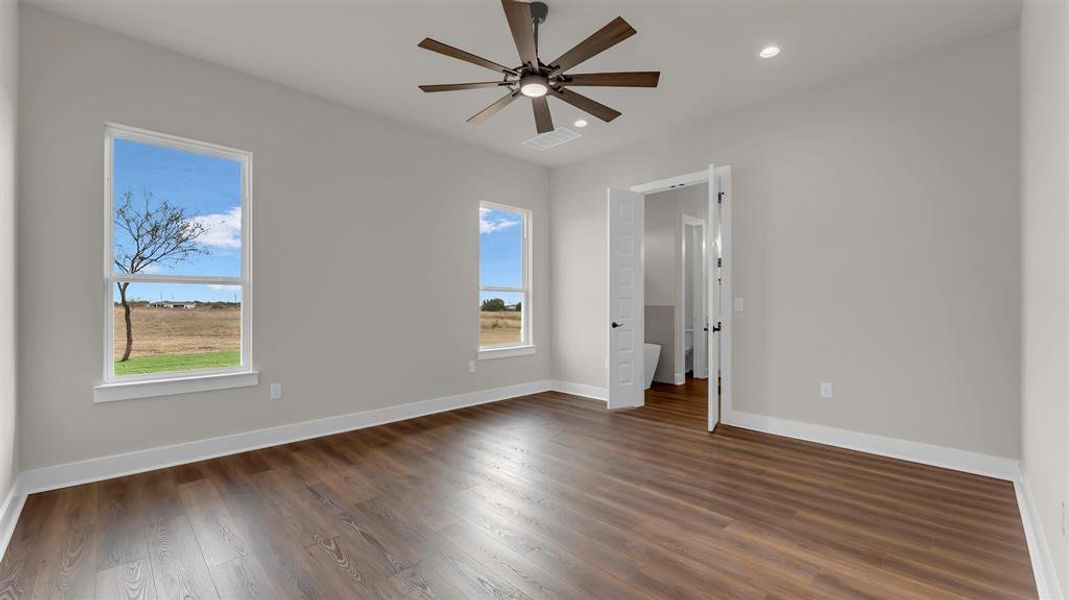 Rich wood-look flooring and tall windows define this versatile bedroom space. Rich wood-look flooring and tall windows define this versatile bedroom space.