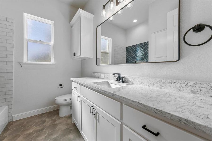 Bathroom with vanity, a healthy amount of sunlight, and toilet