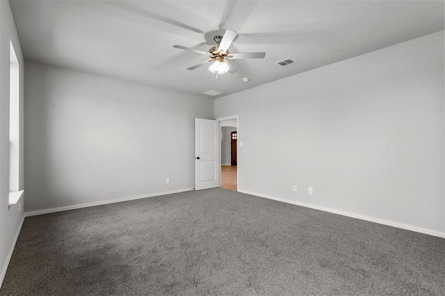 Carpeted spare room with ceiling fan