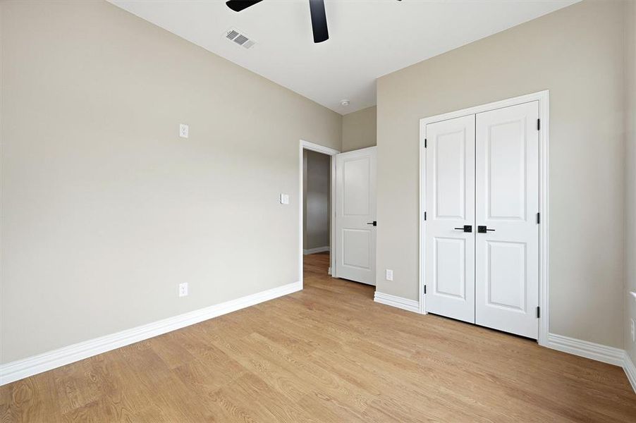Unfurnished bedroom with light wood-style floors, a closet, and ceiling fan Unfurnished bedroom with light wood-style floors, a closet, and ceiling fan