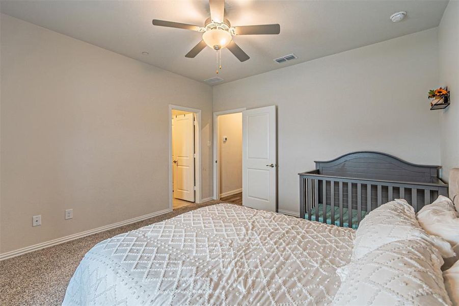 Bedroom with visible vents, baseboards, ceiling fan, and carpet flooring