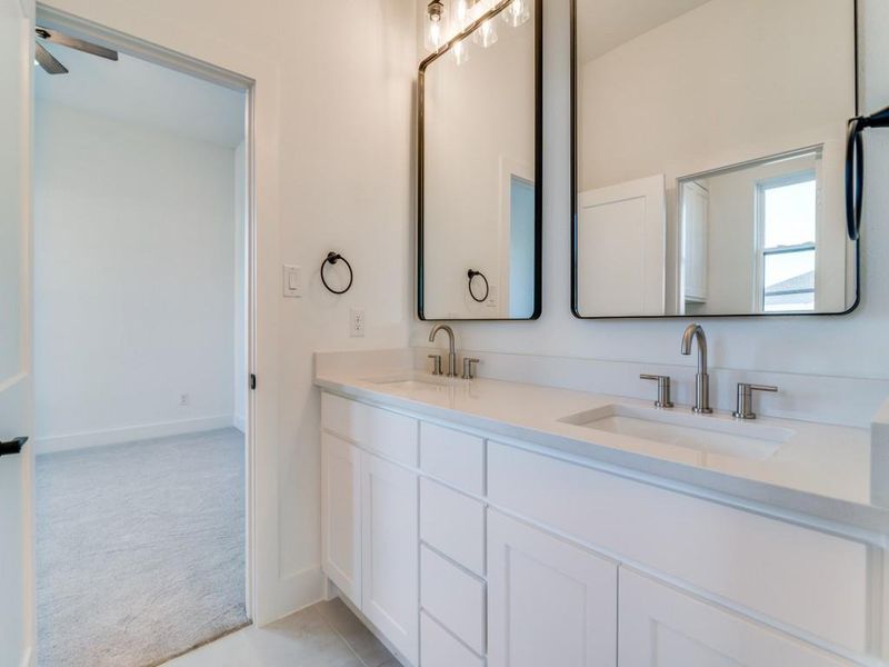 Bathroom featuring double vanity and light carpet