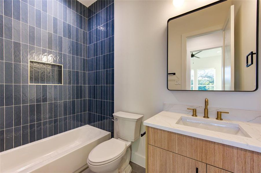 Guest Bathroom 1. All bathrooms feature American Standard toilets, Delta champagne bronze fixtures, 3cm quartz, contemporary cabinetry, and designer tile selections.