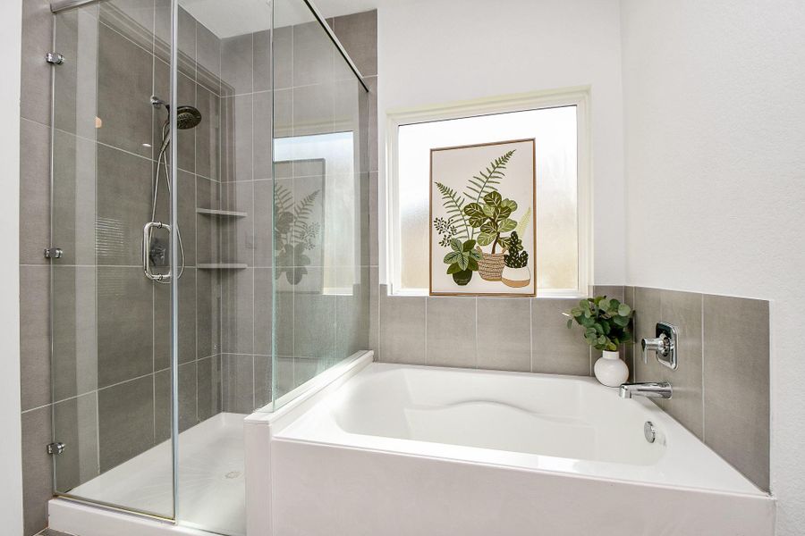 This modern bathroom features a spacious glass-enclosed shower with stylish gray tiles and a separate frameless shower and bathtub. This modern bathroom features a spacious glass-enclosed shower with stylish gray tiles and a separate frameless shower and bathtub.