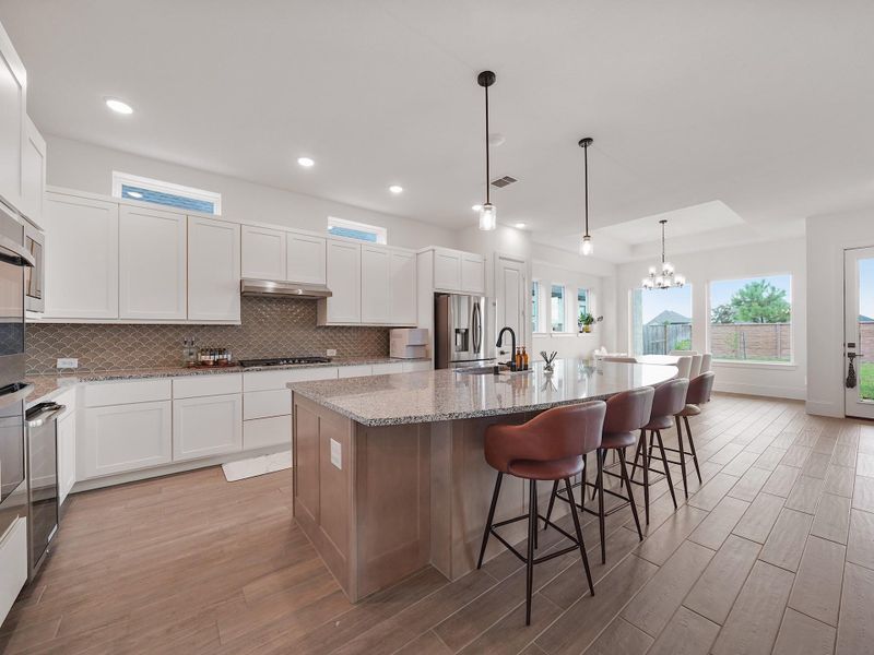 From this angle, you see how seamlessly the kitchen connects to the living and dining areas. With abundant cabinetry, stainless appliances, and a walk-in pantry, this space is as functional as it is beautiful.