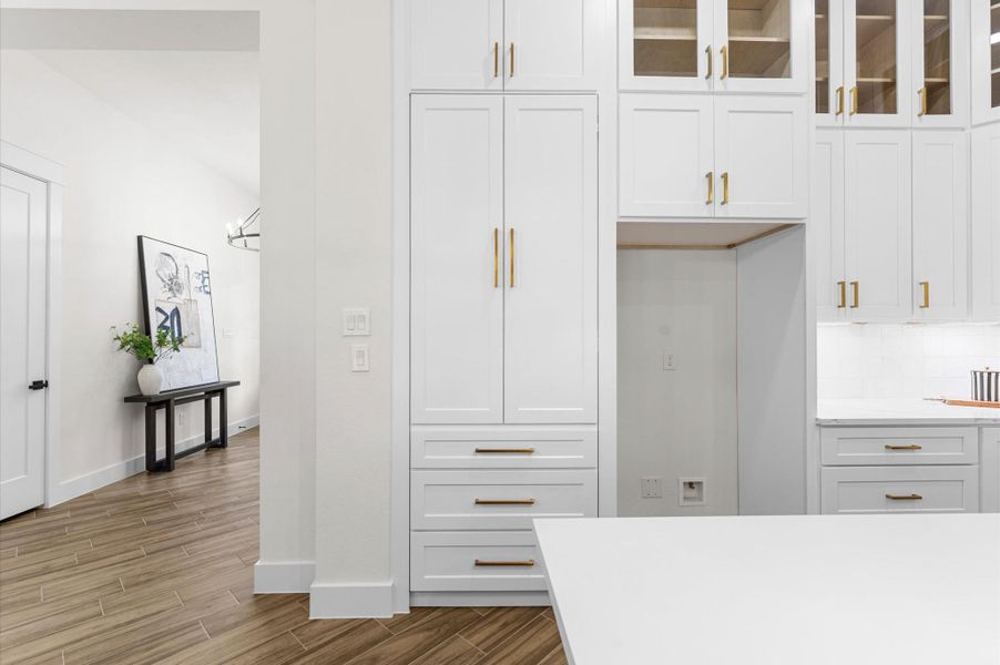 Disguised with a cabinet-style door, the hidden pantry opens to a huge walk-in storage space—ideal for organization and convenience. Disguised with a cabinet-style door, the hidden pantry opens to a huge walk-in storage space—ideal for organization and convenience.
