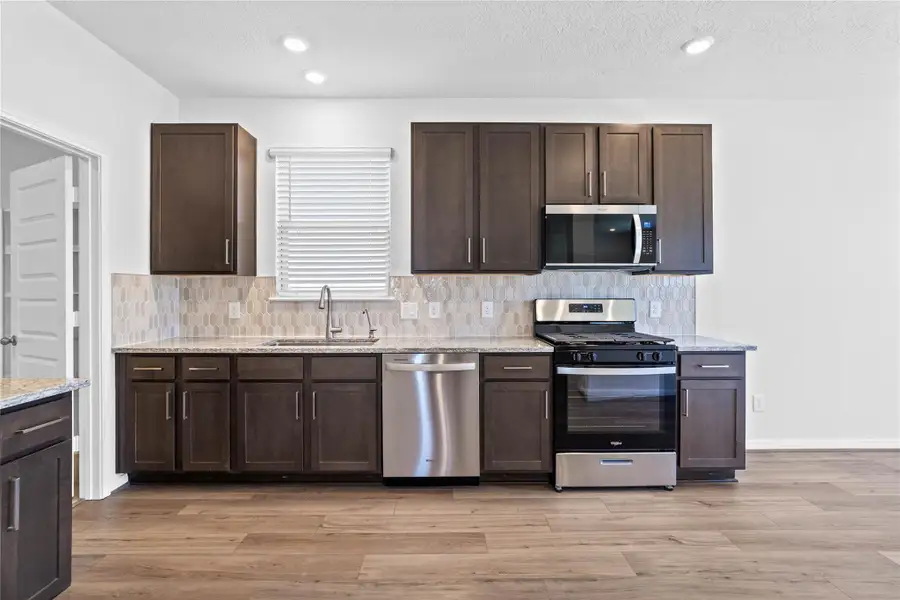 A true chef’s dream, this expansive kitchen boasts high ceilings, rich stained wood cabinets, Granite countertops in Moon White, gorgeous Daltile Miramo picket backsplash, stainless steel appliances, recessed lighting, extended counter space, and a pantry—all with a clear view of the spacious family room. A true chef’s dream, this expansive kitchen boasts high ceilings, rich stained wood cabinets, Granite countertops in Moon White, gorgeous Daltile Miramo picket backsplash, stainless steel appliances, recessed lighting, extended counter space, and a pantry—all with a clear view of the spacious family room.