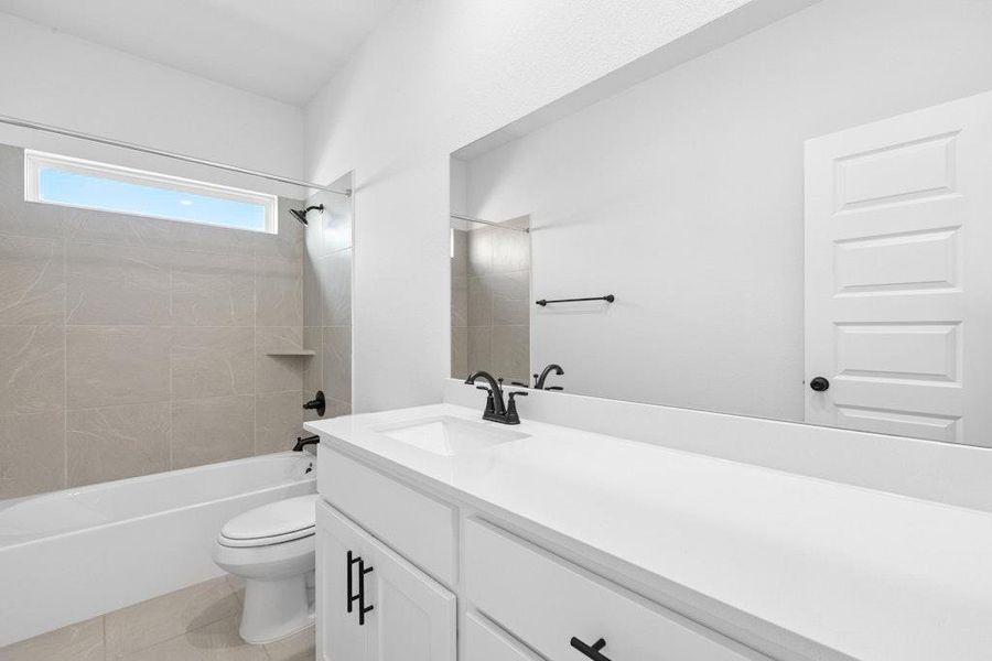 Full bathroom featuring vanity, bathing tub / shower combination, and light tile patterned flooring Full bathroom featuring vanity, bathing tub / shower combination, and light tile patterned flooring