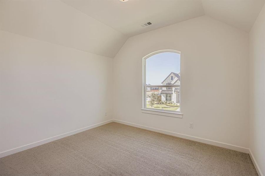 Bonus room featuring lofted ceiling and light colored carpet Bonus room featuring lofted ceiling and light colored carpet