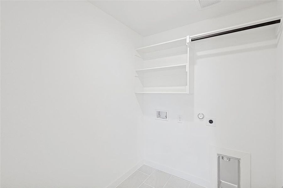 Laundry room featuring gas dryer hookup, hookup for a washing machine, light tile patterned floors, and hookup for an electric dryer