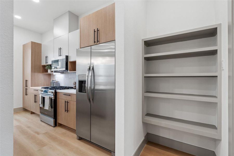 Blending seamlessly into the kitchen’s modern design, this built-in wall shelving offers smart, additional storage just steps from the main prep area. Whether styled as a pantry, coffee bar nook, or display for cookbooks and ceramics, it adds both function and flexibility to the heart of the home.