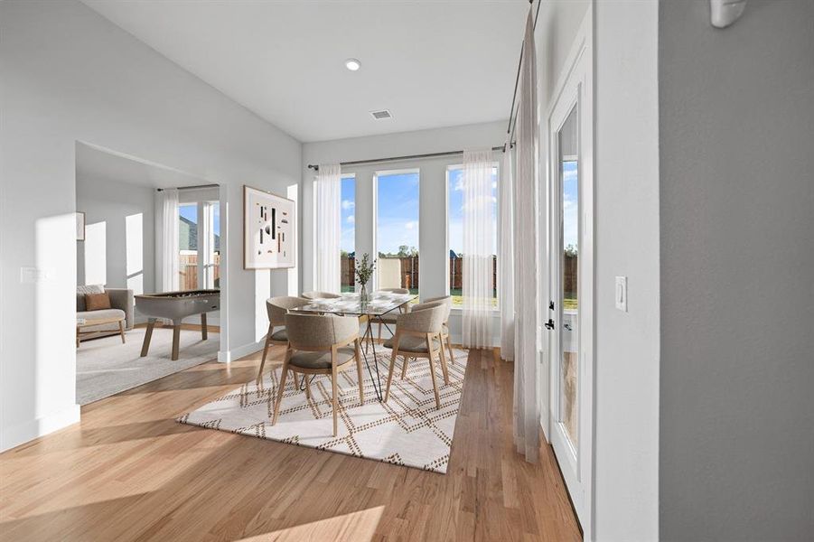 Dining room with light wood-style floors and recessed lighting Dining room with light wood-style floors and recessed lighting
