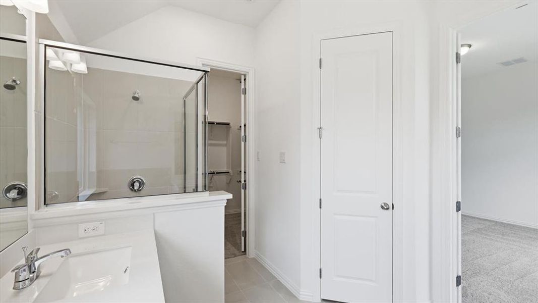 Modern bathroom featuring a walk-in shower with glass enclosure, single vanity with integrated sink, chrome faucet, and tile flooring Modern bathroom featuring a walk-in shower with glass enclosure, single vanity with integrated sink, chrome faucet, and tile flooring